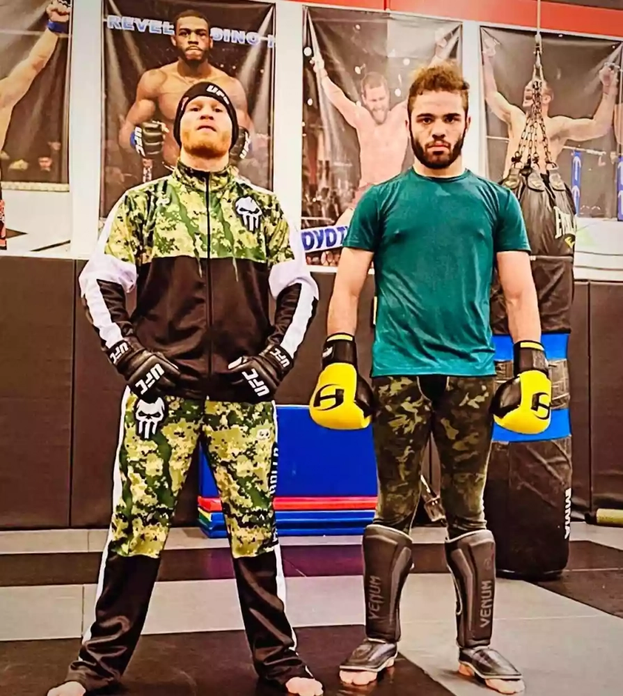 Custom sublimated track jacket in green camo and black for team wear with moisture-wicking material